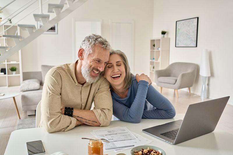 Happy Mature Older Family Couple Laughing, Bonding Sitting At Ho